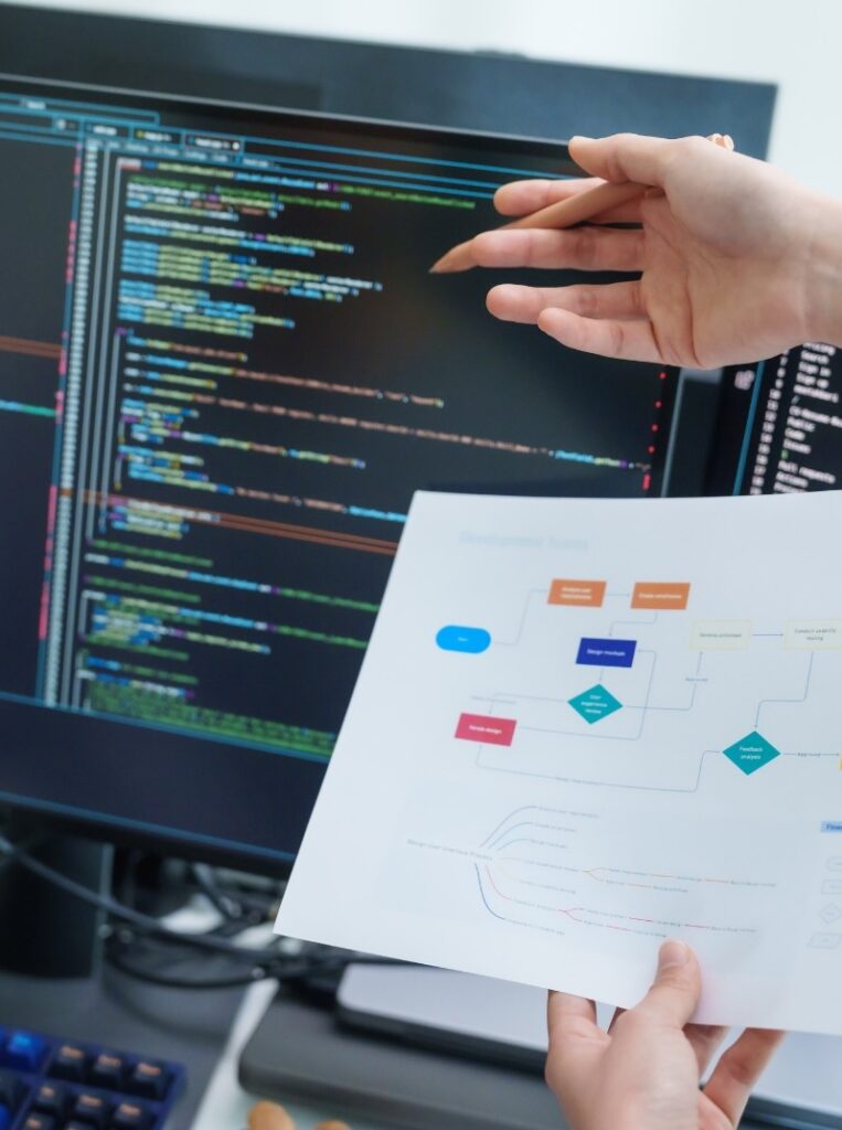 Software consulting and technology strategy workshop with developers reviewing application architecture, code, and business process diagrams.