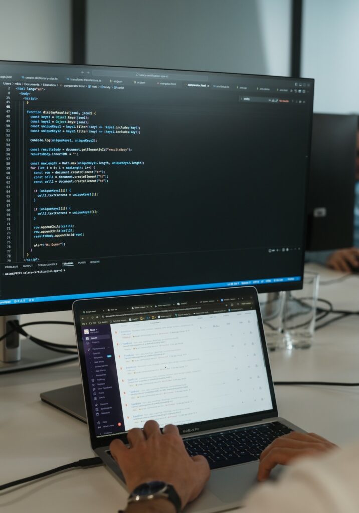 Image showing a computer screen with code and a laptop.